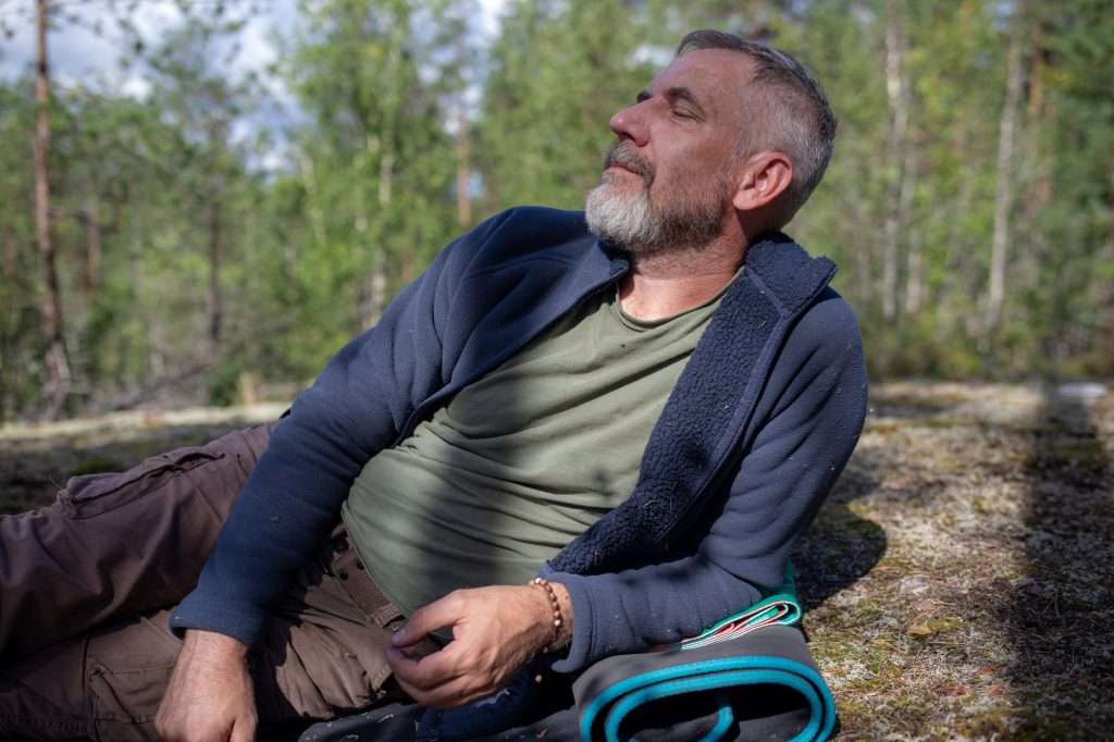 Middle-aged man resting outdoors after a hike