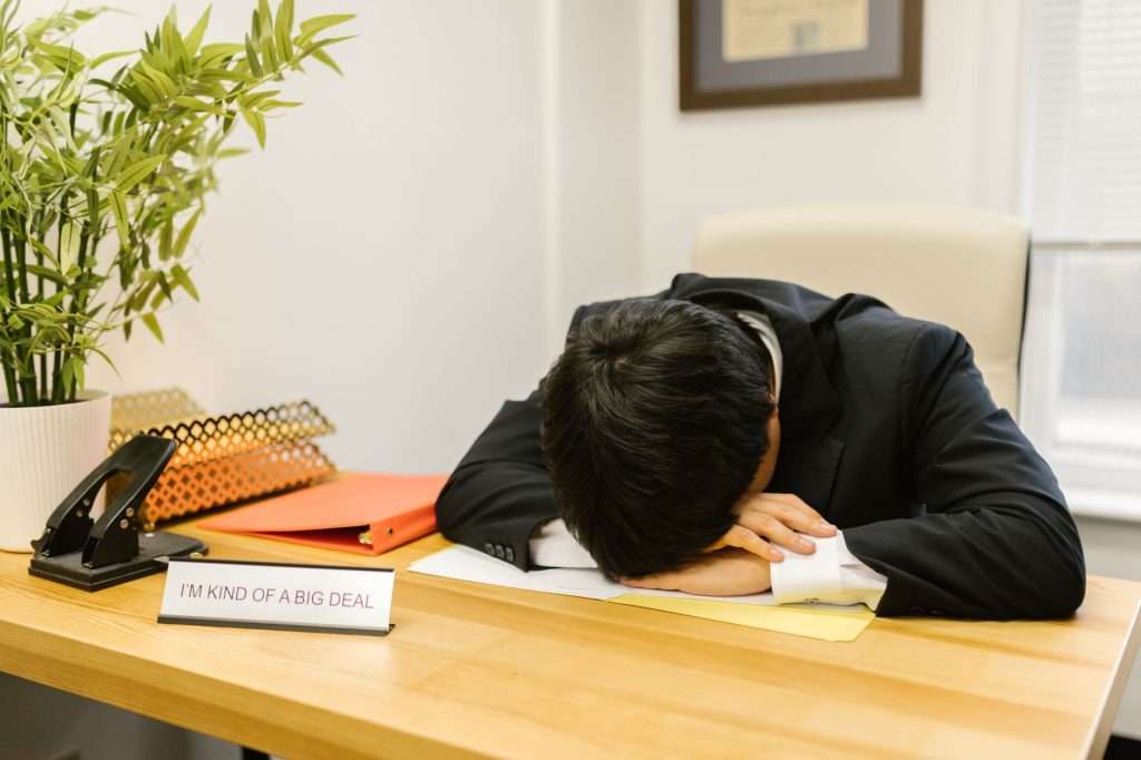 Ultra Bann Business professional asleep at desk in office